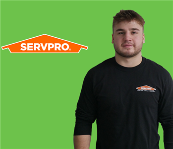 Man in front of SERVPRO green and logo