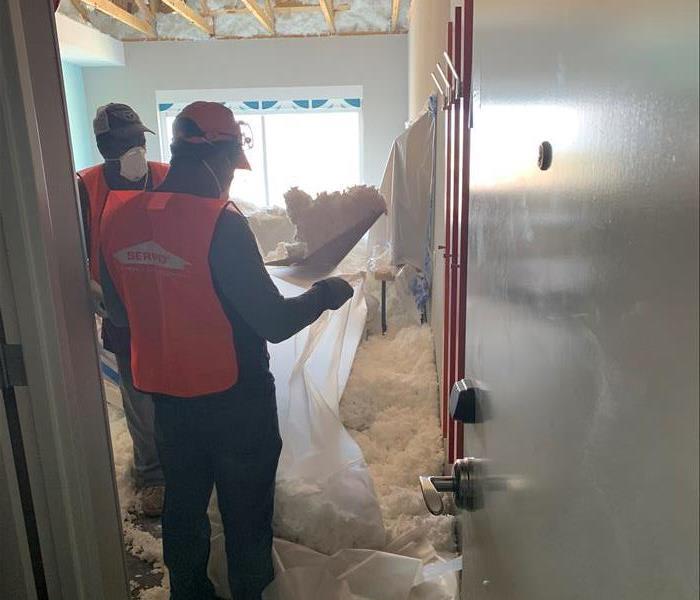 Team members removing insulation