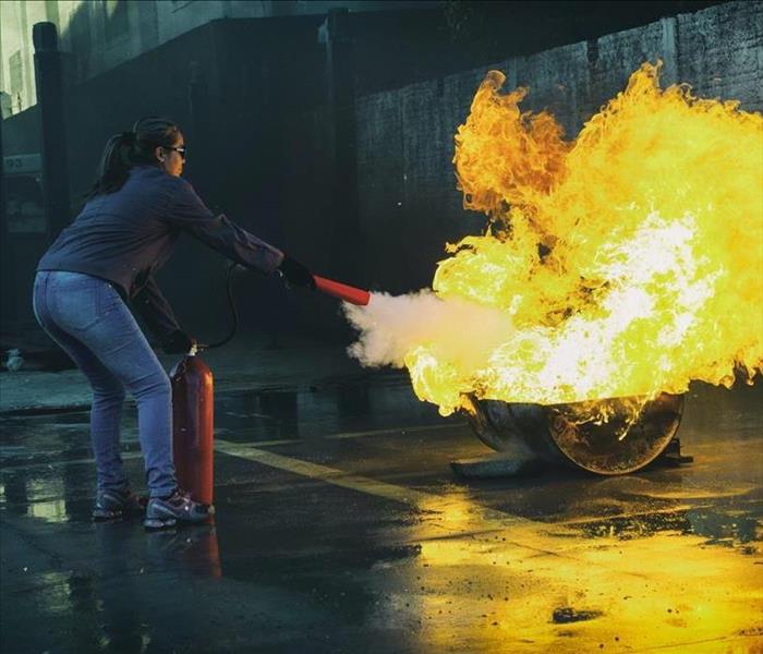 Girl Using the PASS Method to extinguish the flames